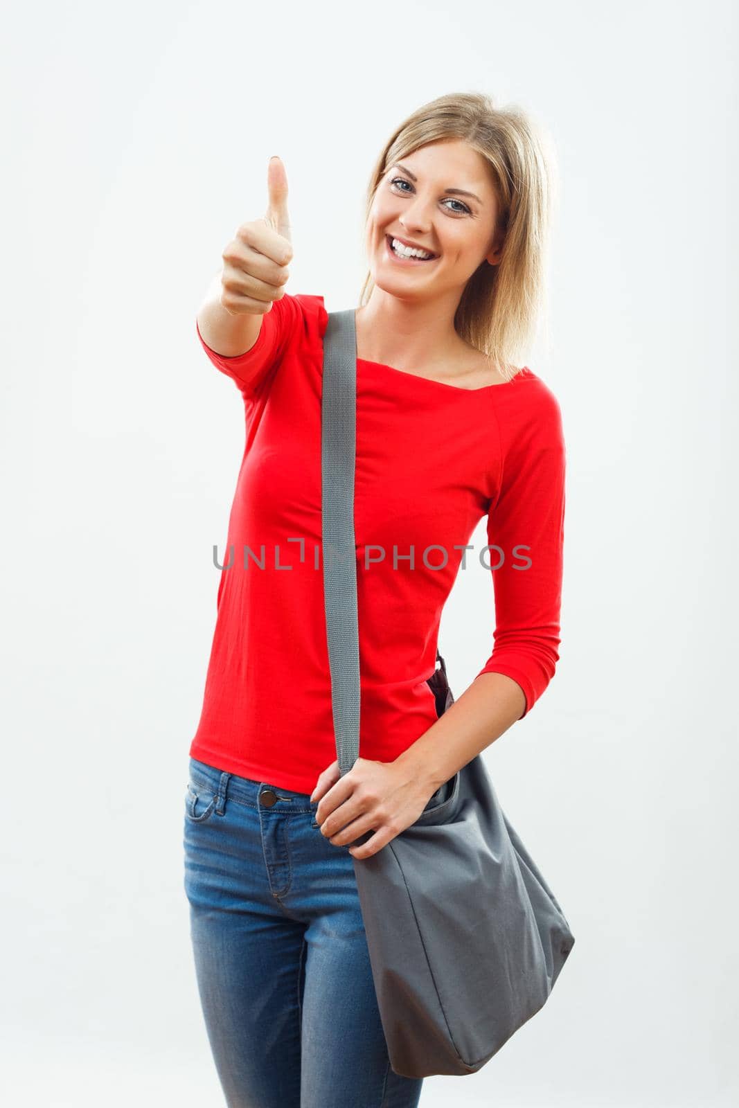 Portrait of beautiful female student showing thumb up.