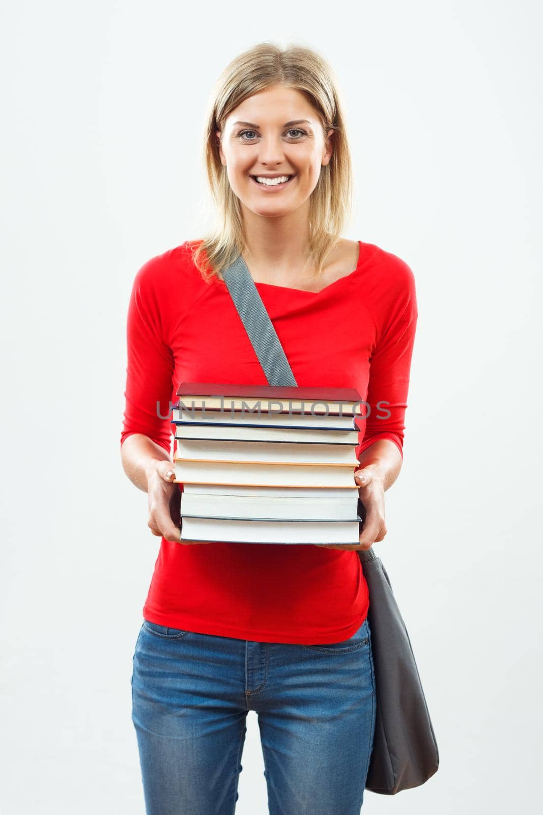 Happy female student holding books.