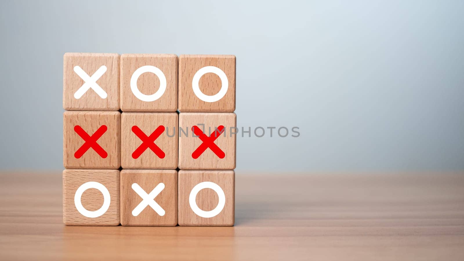 Tic Tac Toe game made of wooden blocks. Front view of wooden OX game on wooden table.Business marketing strategy planning concept. Business competitor assessment concept. by Unimages2527
