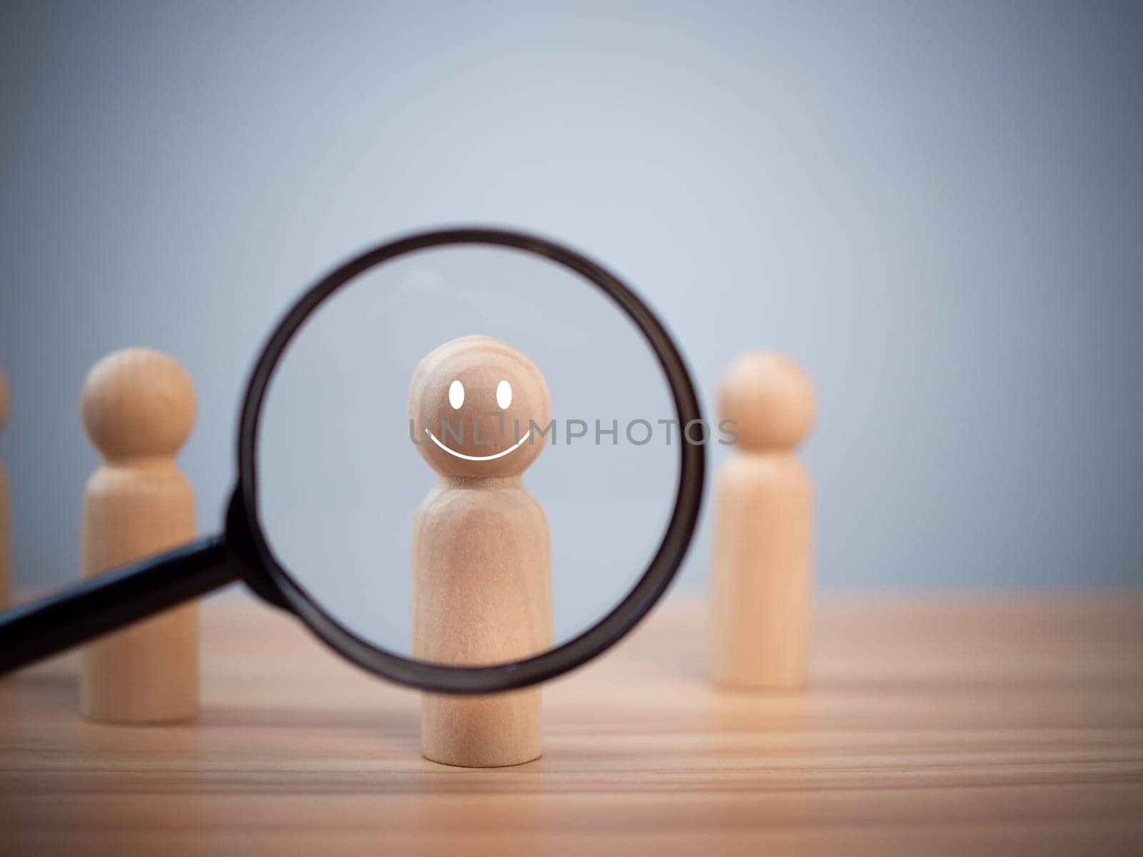 The wooden doll smiled through the magnifying glass inside. Represents customer satisfaction and happiness surveys. Great Customer Assessment Concept