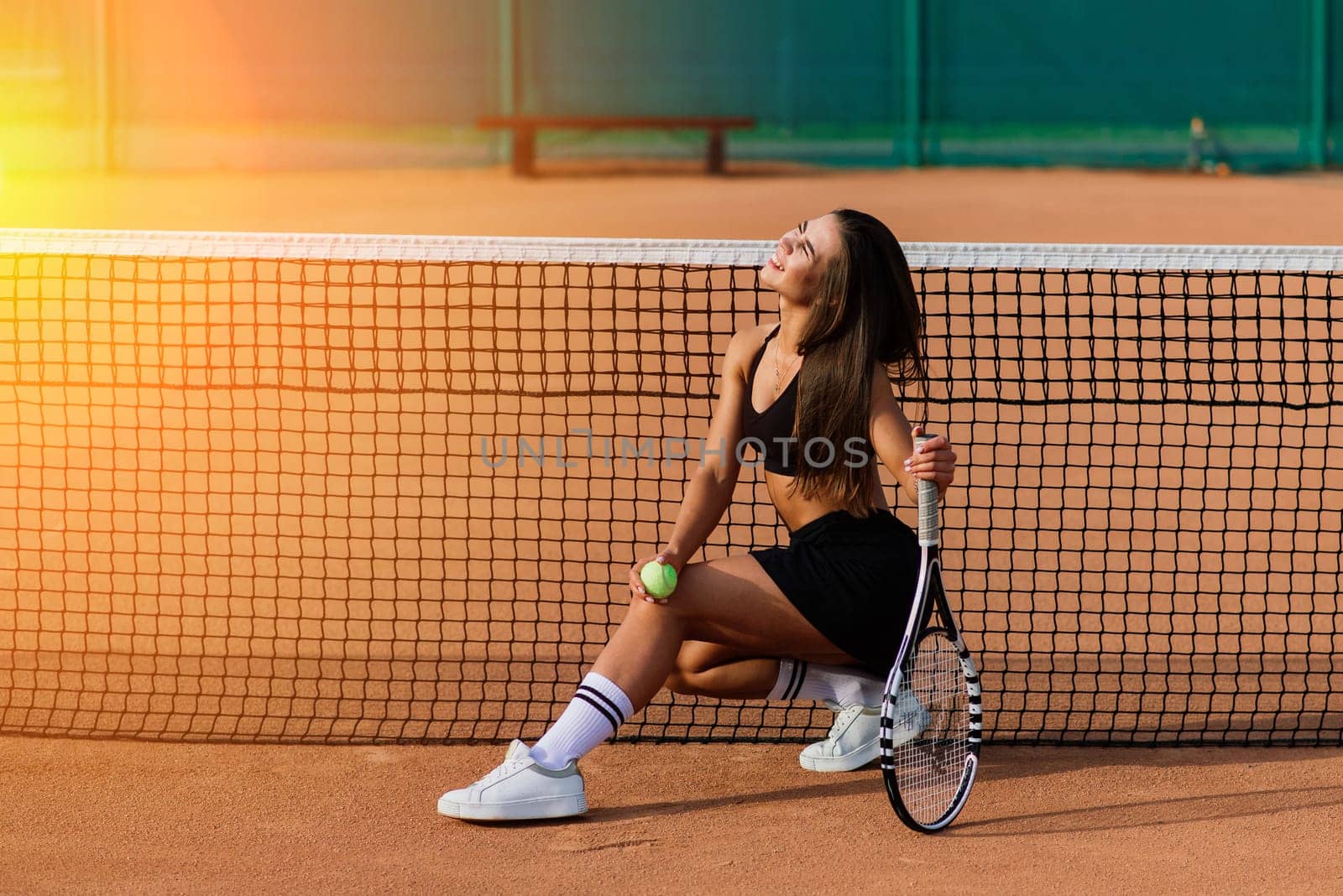 Beautiful Woman On Tennis Court. Portrait Of Stylish Sexy Girl In Black Trendy Sportswear Holding Tennis Racket On Outdoor Court.