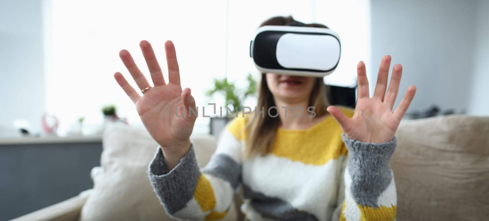 Close-up view of happy young woman using virtual reality headset by kuprevich