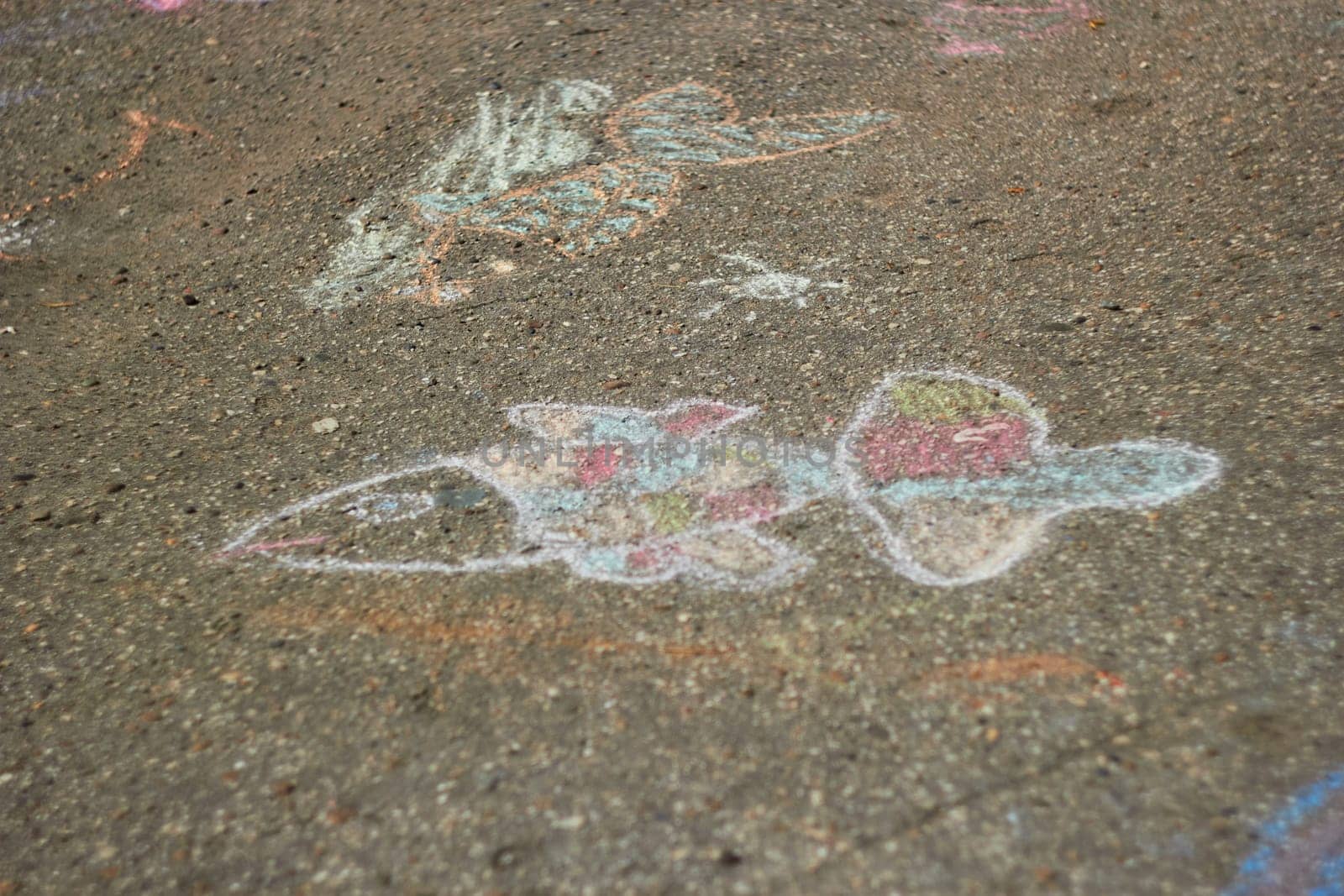 Photograph of children drawing with chalk on pavement. fish. Children entertainment. soft focus.