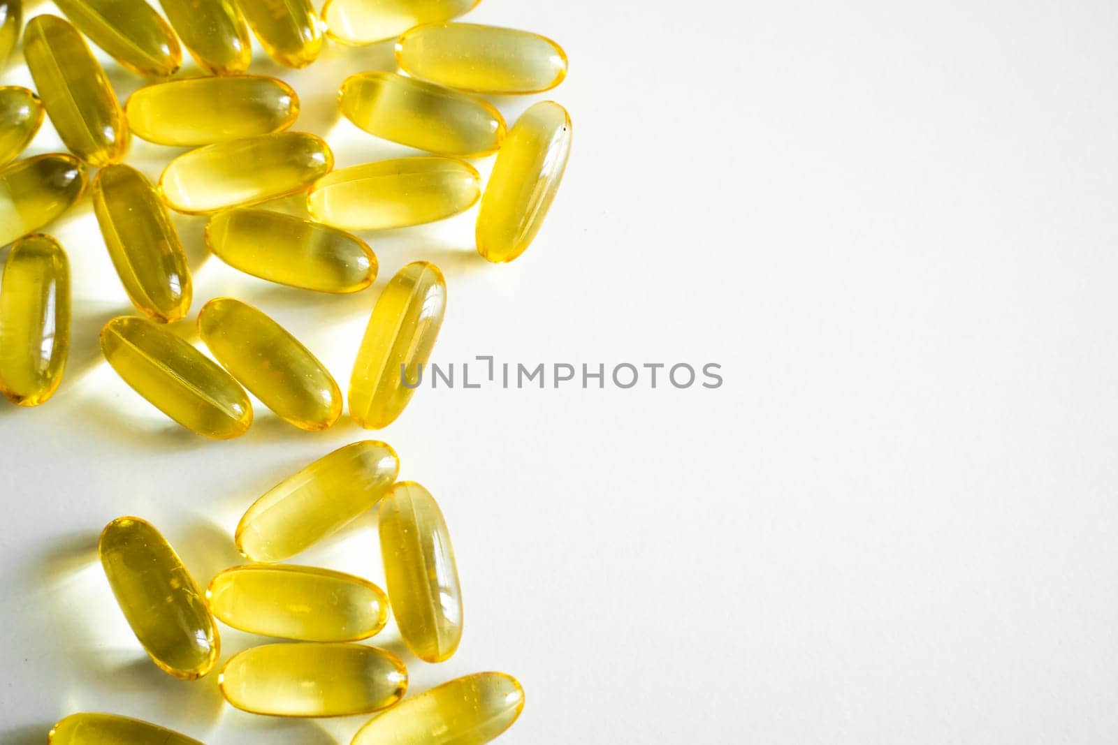Oil filled capsules, softgel of food supplements. Fish oil, omega 3. Yellow softgels on white, copy space. by vovsht