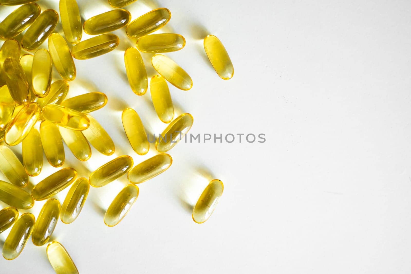 Fish oil capsules, omega 3, on white surface. Oil filled capsules, softgel of food supplements