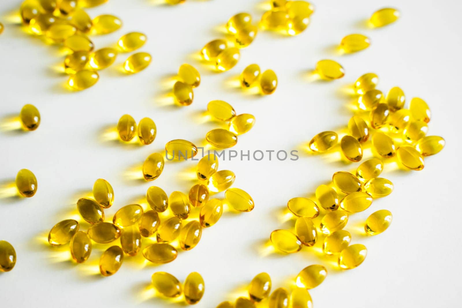 Oil filled capsules, softgel of food supplements. Vitamin D3. Yellow softgels, top view, copy space. Nutritional supplements