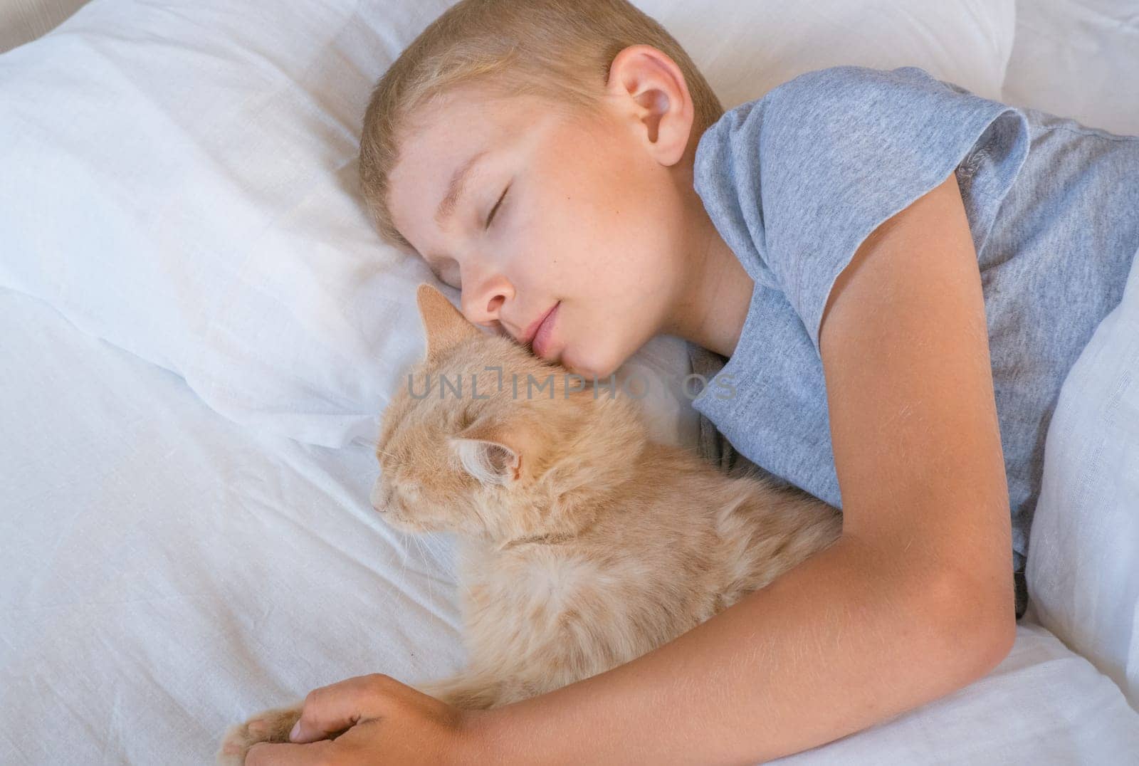 A child in bed cannot fall asleep, yawns, grimaces and plays with a ginger cat