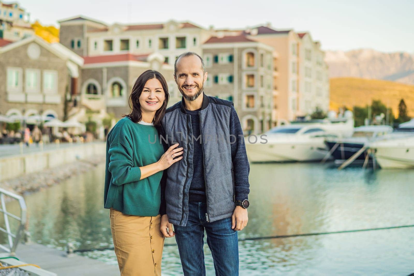 Couple in love tourists enjoying the views of Architecture and luxury yachts in Lustica Bay, Montenegro. Travel around Montenegro concept. Go Everywhere.