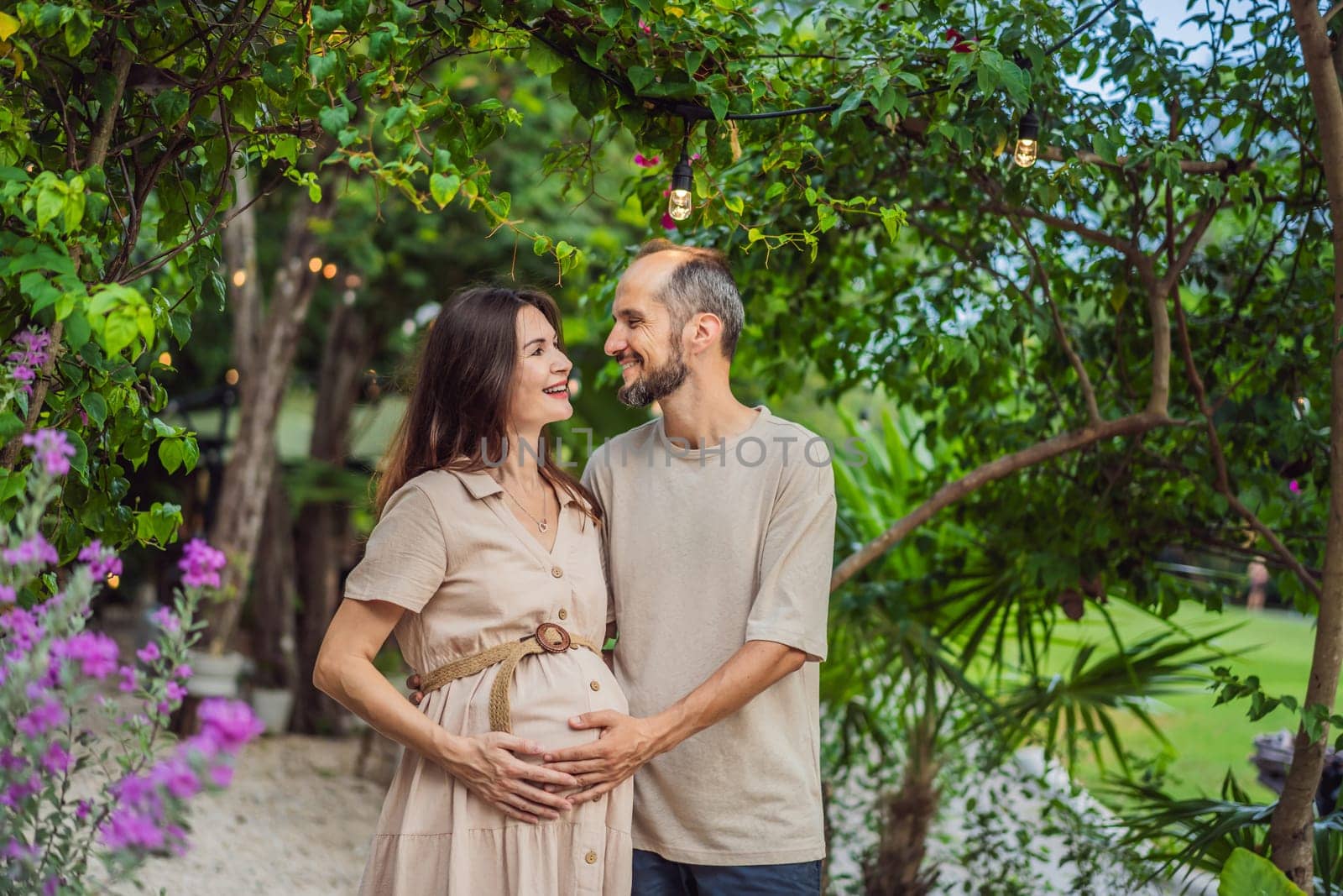 A blissful scene in the park as a radiant pregnant woman after 40 and her loving husband after 40, cherish the joy of parenthood together, surrounded by nature's serenity.