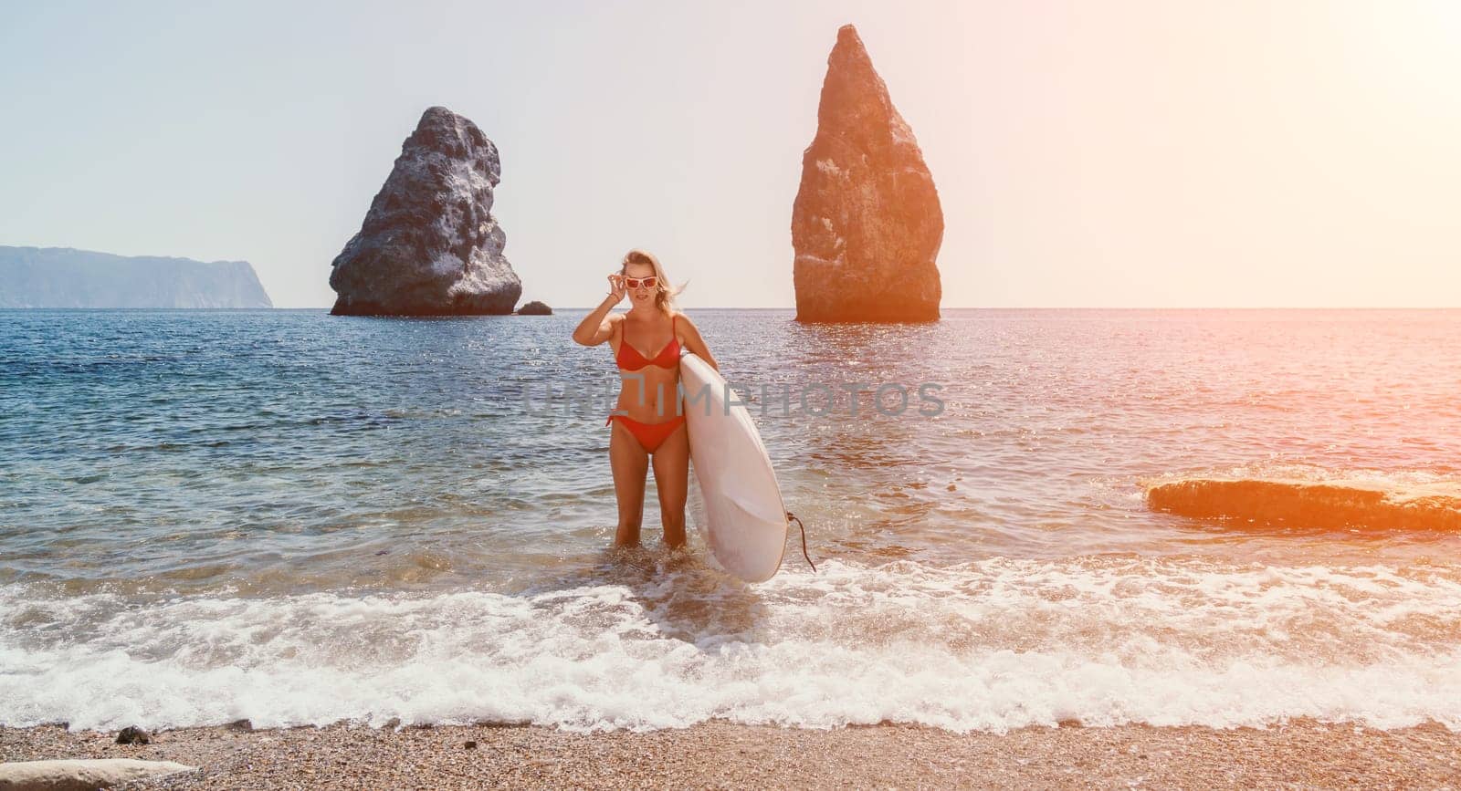 Woman sea sup. Close up portrait of happy young caucasian woman with blond hair looking at camera and smiling. Cute woman portrait in red bikini posing on sup board in the sea by panophotograph