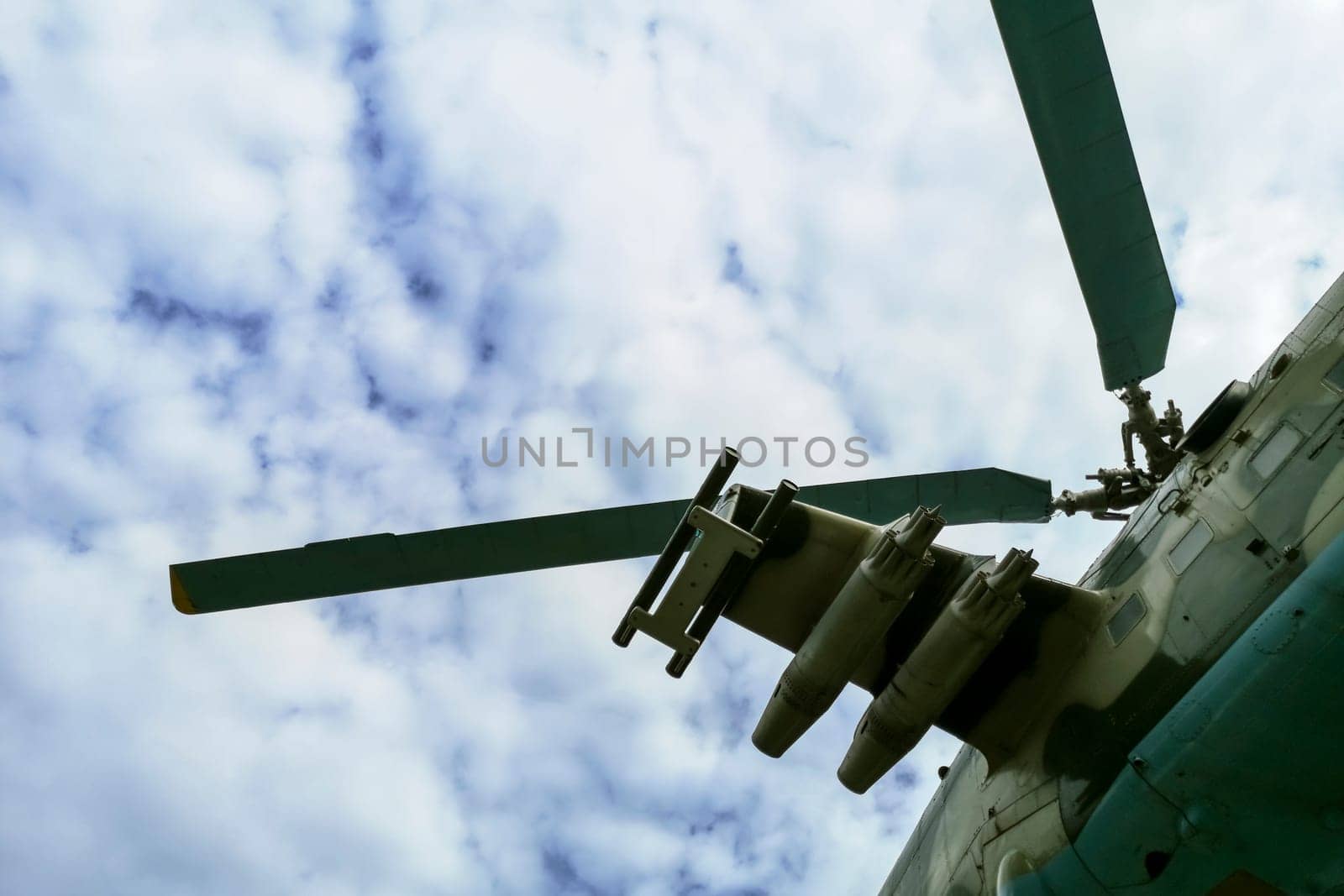 Helicopter flying under sky covered with clouds. Flying military helicopter.