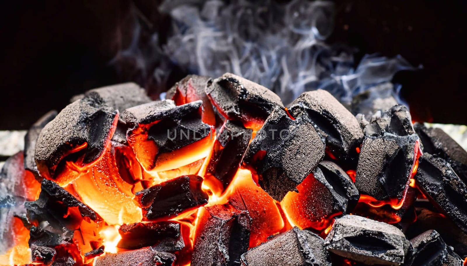 Charcoal. Closeup shot of a pile of charcoal with fire for a barbecue on a dark background