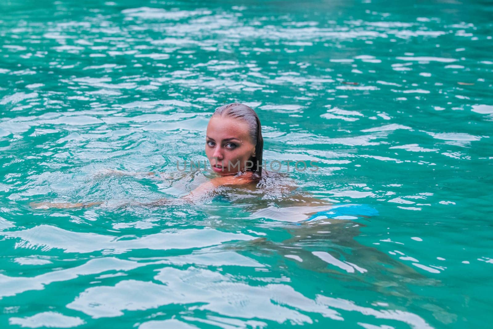 Woman swimming and relaxing in blue water of sea in Thailand