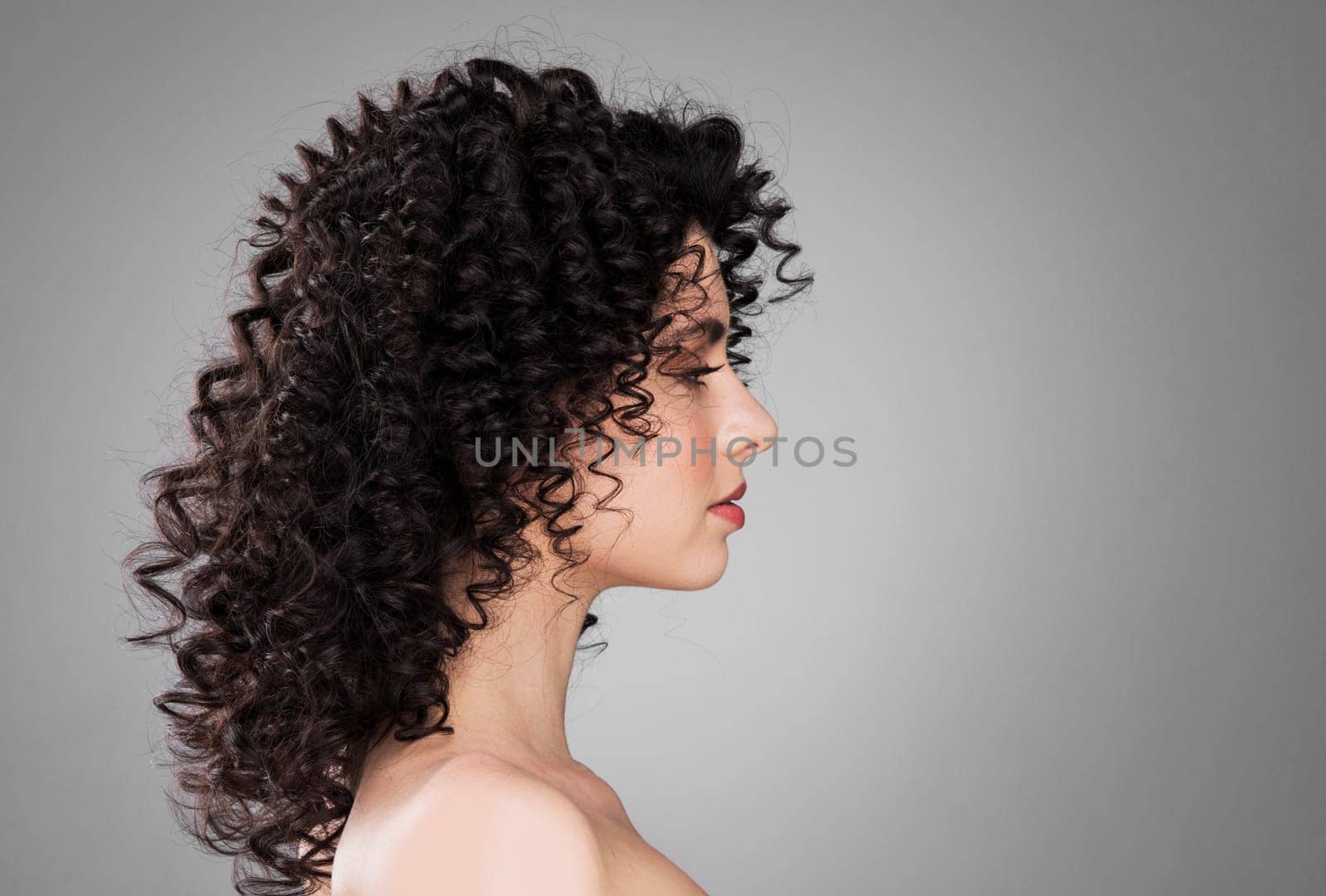 Profile portrait of young caucasian woman with curly hair