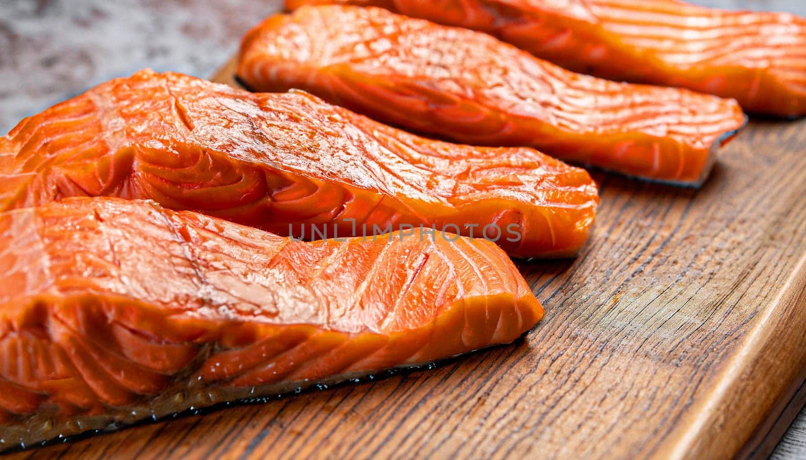 Grilled salmon steaks with ingredients on wooden cutting board in the kitchen
