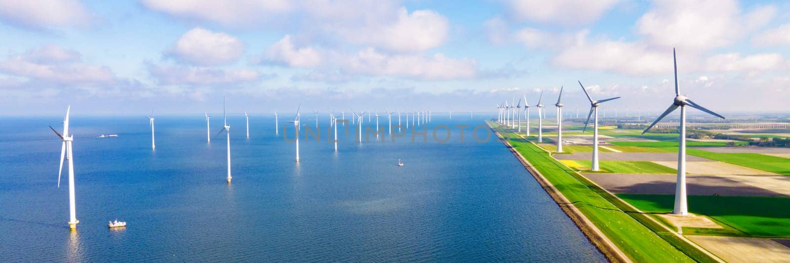 Wndmill park in the ocean aerial view with wind turbine Flevoland Netherlands Ijsselmeer. Green Energy in the Netherlands on a sunny day