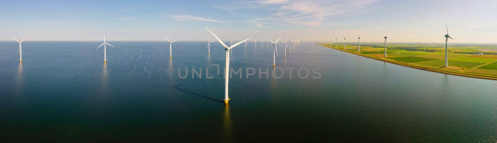 Wndmill park in the ocean aerial view with wind turbine Flevoland Netherlands Ijsselmeer. Green Energy in the Netherlands on a sunny day