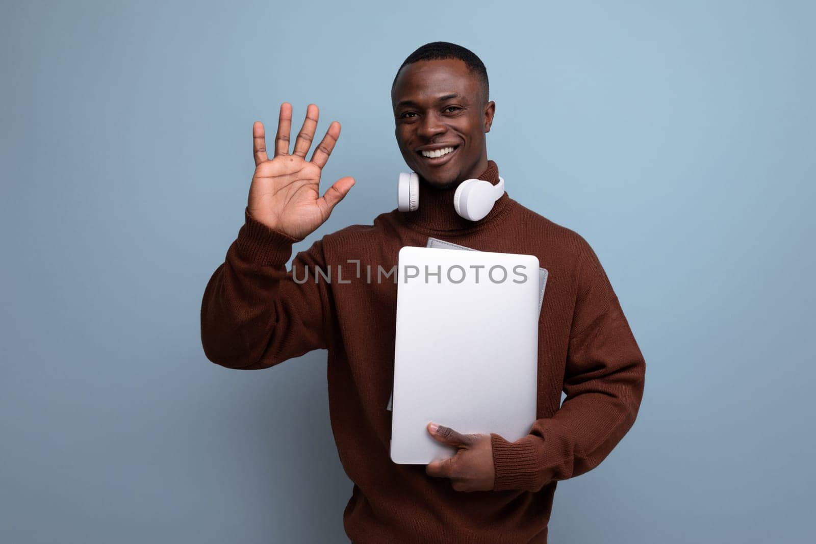 successful young african man businessman with laptop and headphones on background with copy space.