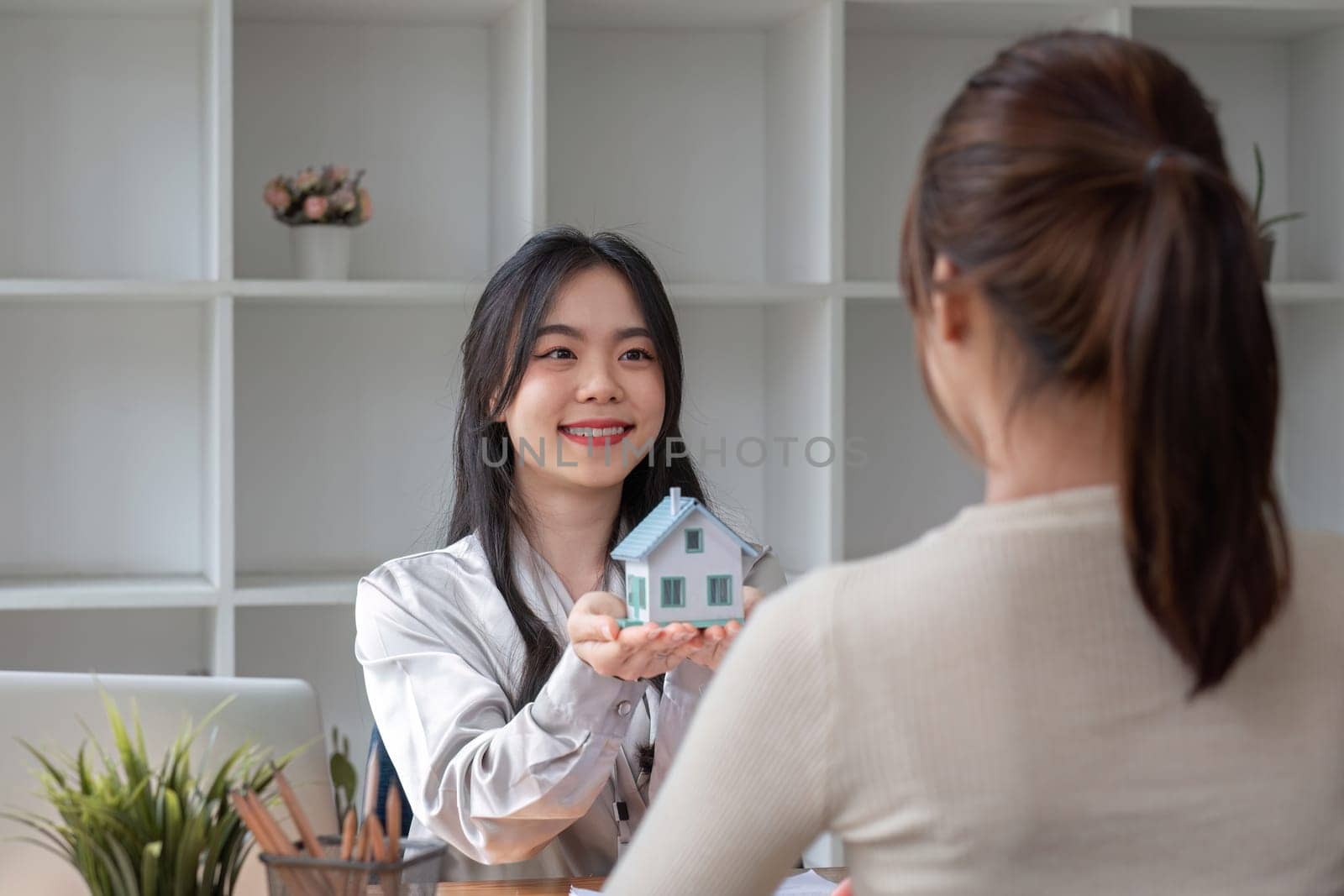 real estate agent or banker handing over a key to their customer after signing a contract.