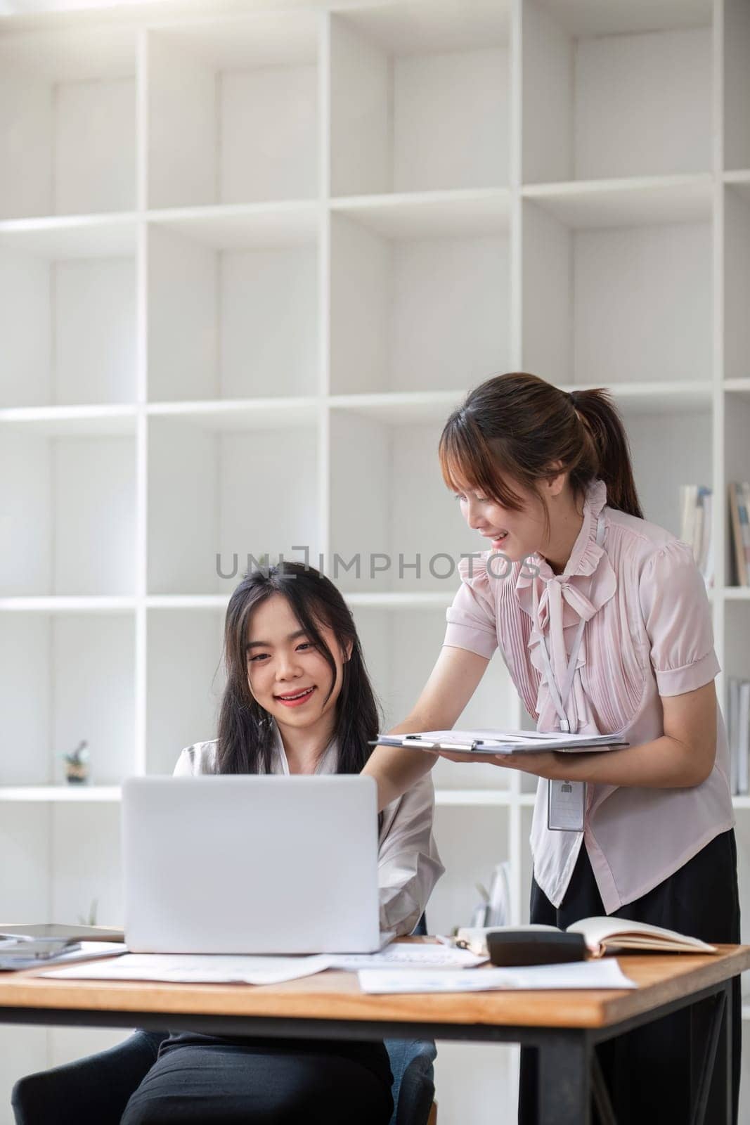 Two Young Asian businesswoman discuss with new startup project Idea presentation, analyze statistics and investment market at office.