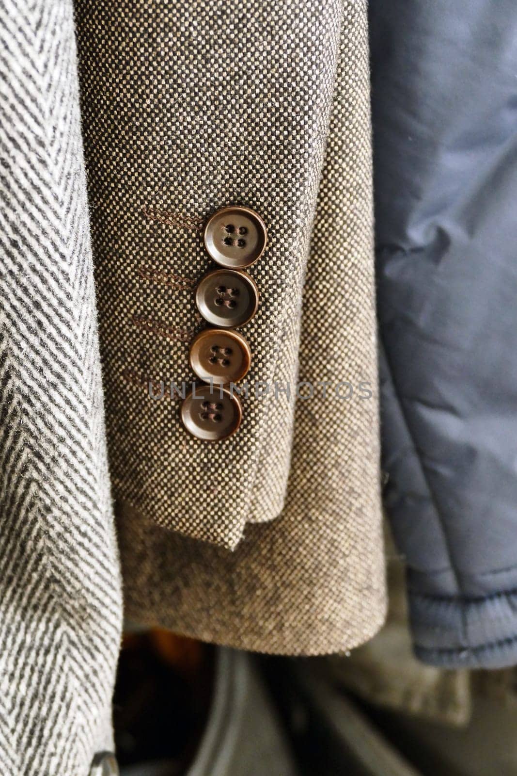 the cufflinks of the jacket hanging in the closet are visible,close-up coat-jacket, by nhatipoglu