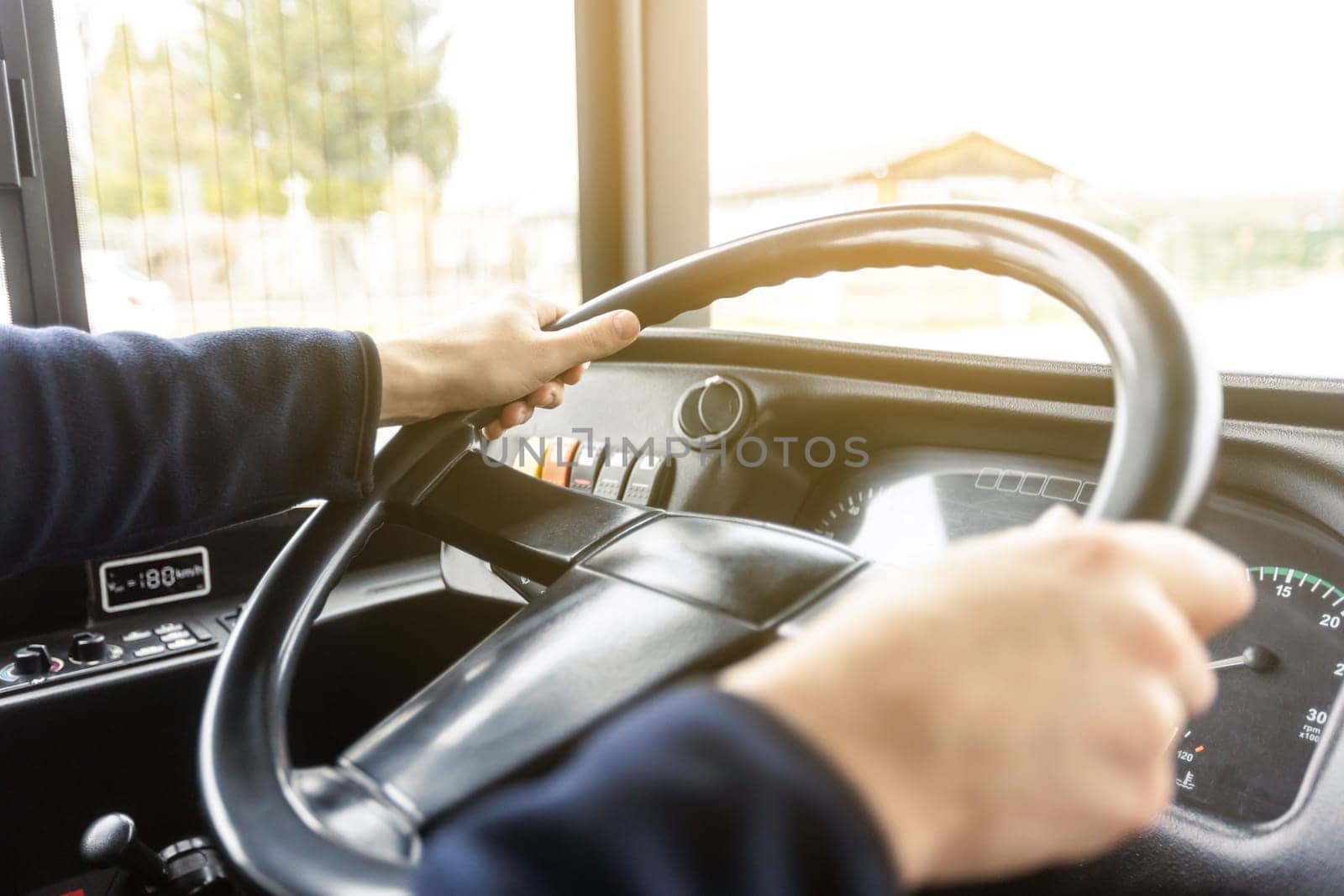 Hands of the driver in a modern bus according to a ride, detail of the bus drivers steering wheel and driving a passenger bus, transportation concept