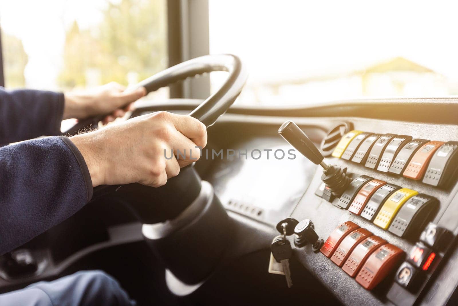 Hands of the driver in a modern bus according to a ride, detail of the bus drivers steering wheel and driving a passenger bus, transportation concept
