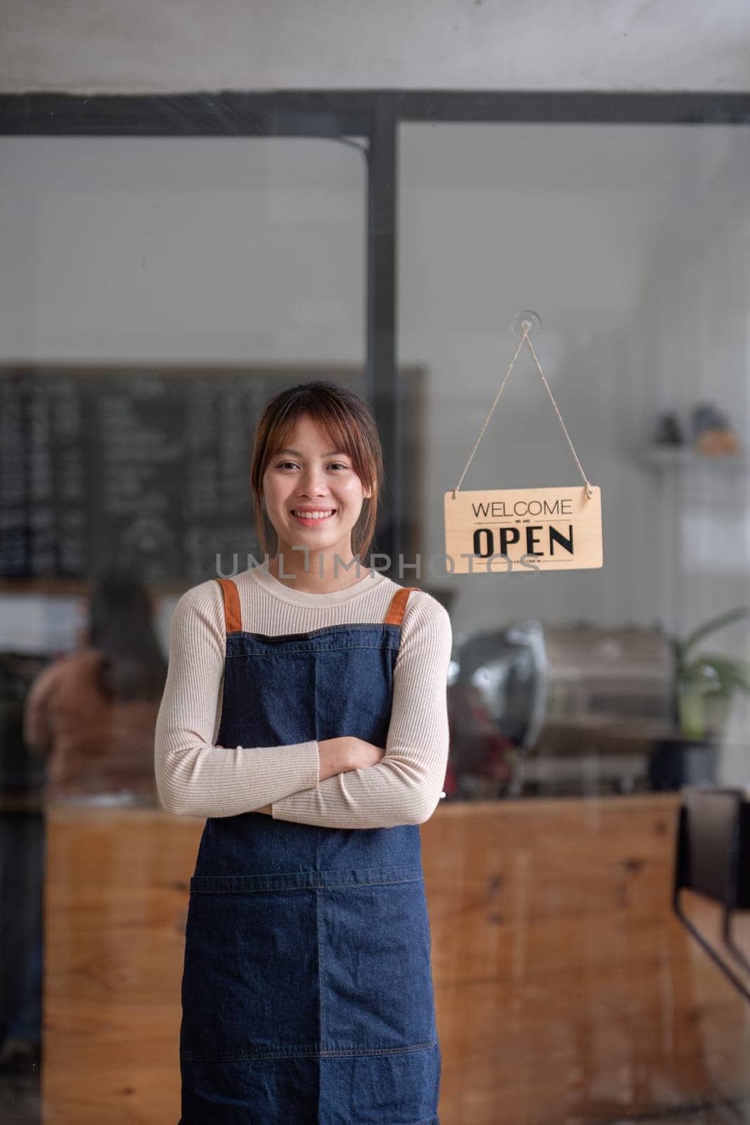 Successful small business owner. Beautiful girl with apron holding tablet standing in coffee shop restaurant. Portrait of asian woman barista cafe owner. by wichayada
