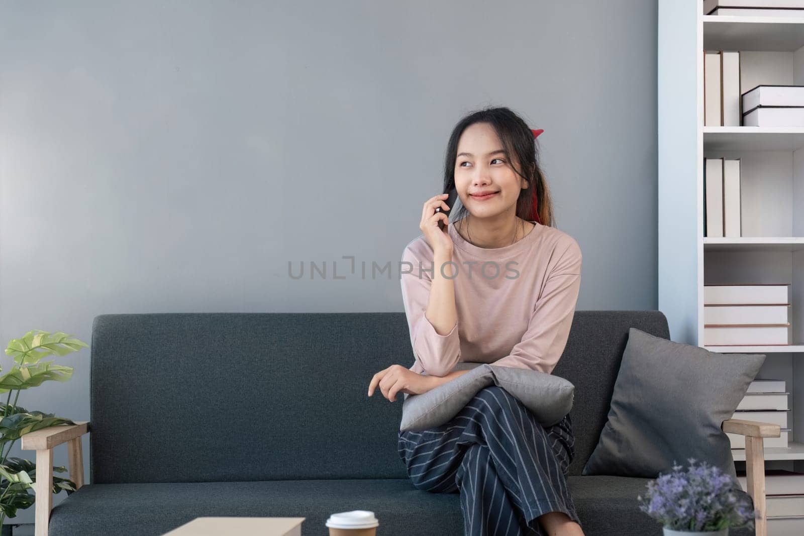 Happy beautiful young asian woman listening good news involved in pleasant phone call conversation, distracted from computer work, talking speaking with friends, distant communication concept.