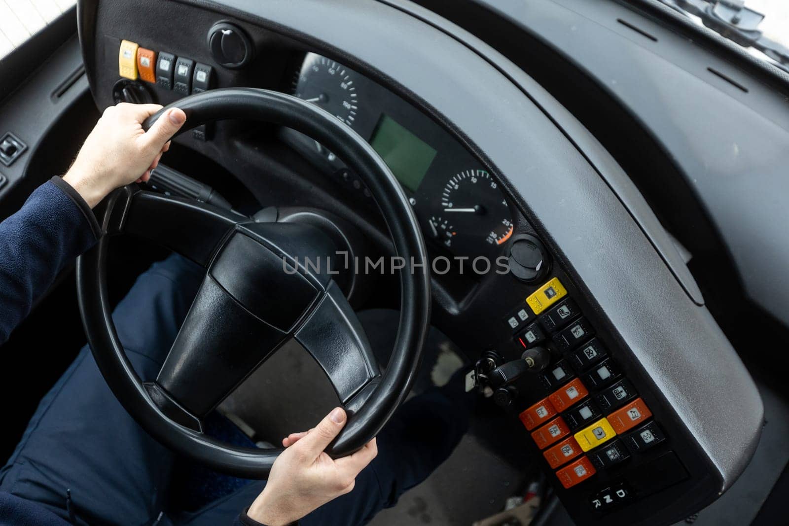 Cockpit or cabin of public transport, bus driver holding steering wheel, concept of an urban public transportation