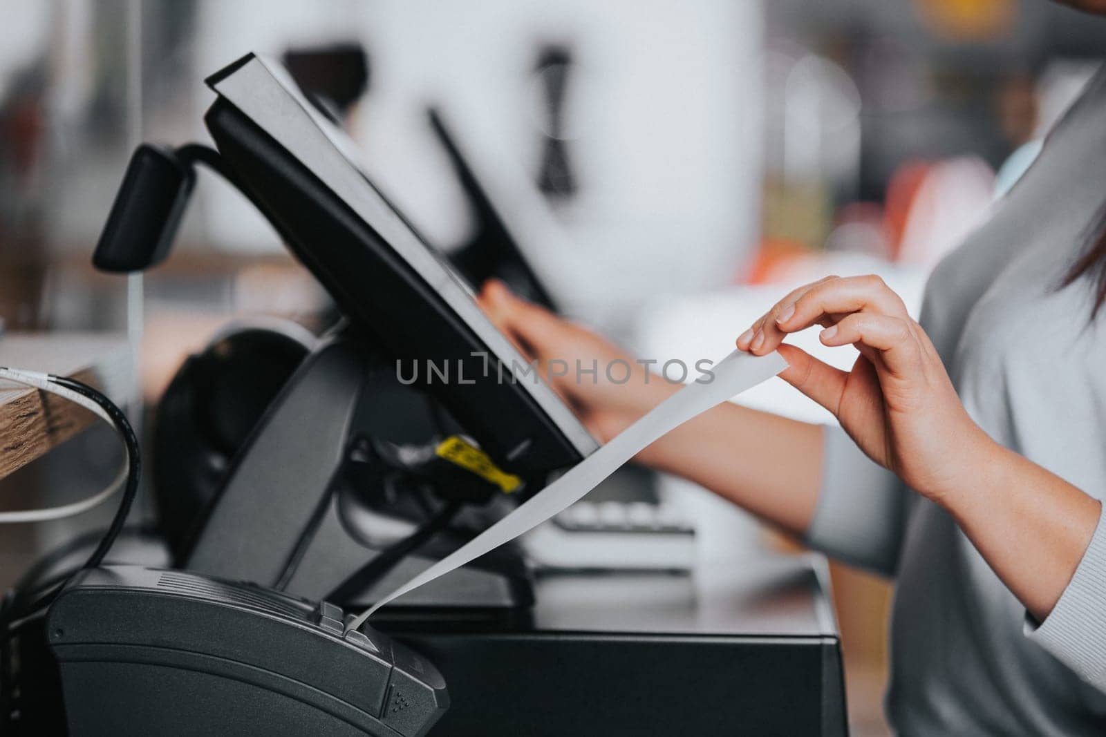 Saleswoman printing invoice or receipt for the customer in the shopping center, POS system, finance concept