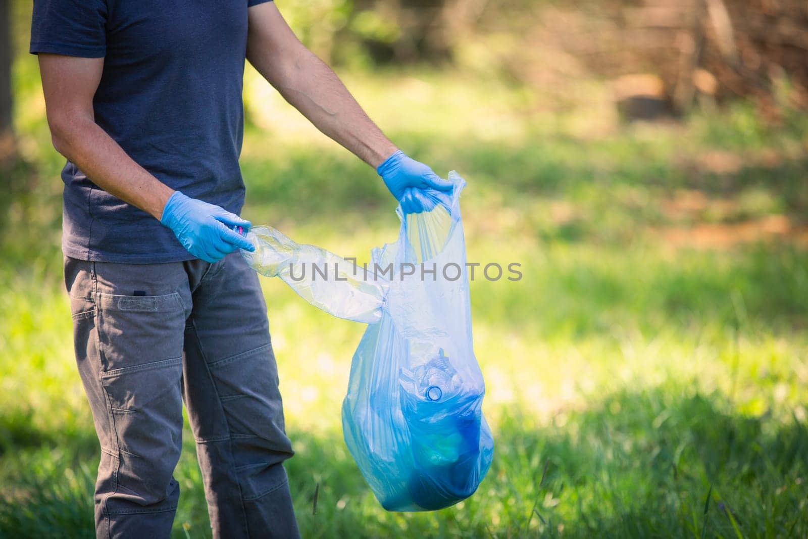 Man picking up plastic bottle, garbage collecting in forest cleaning planet, help garbage collection charity environment, garbage in the forest by Kadula