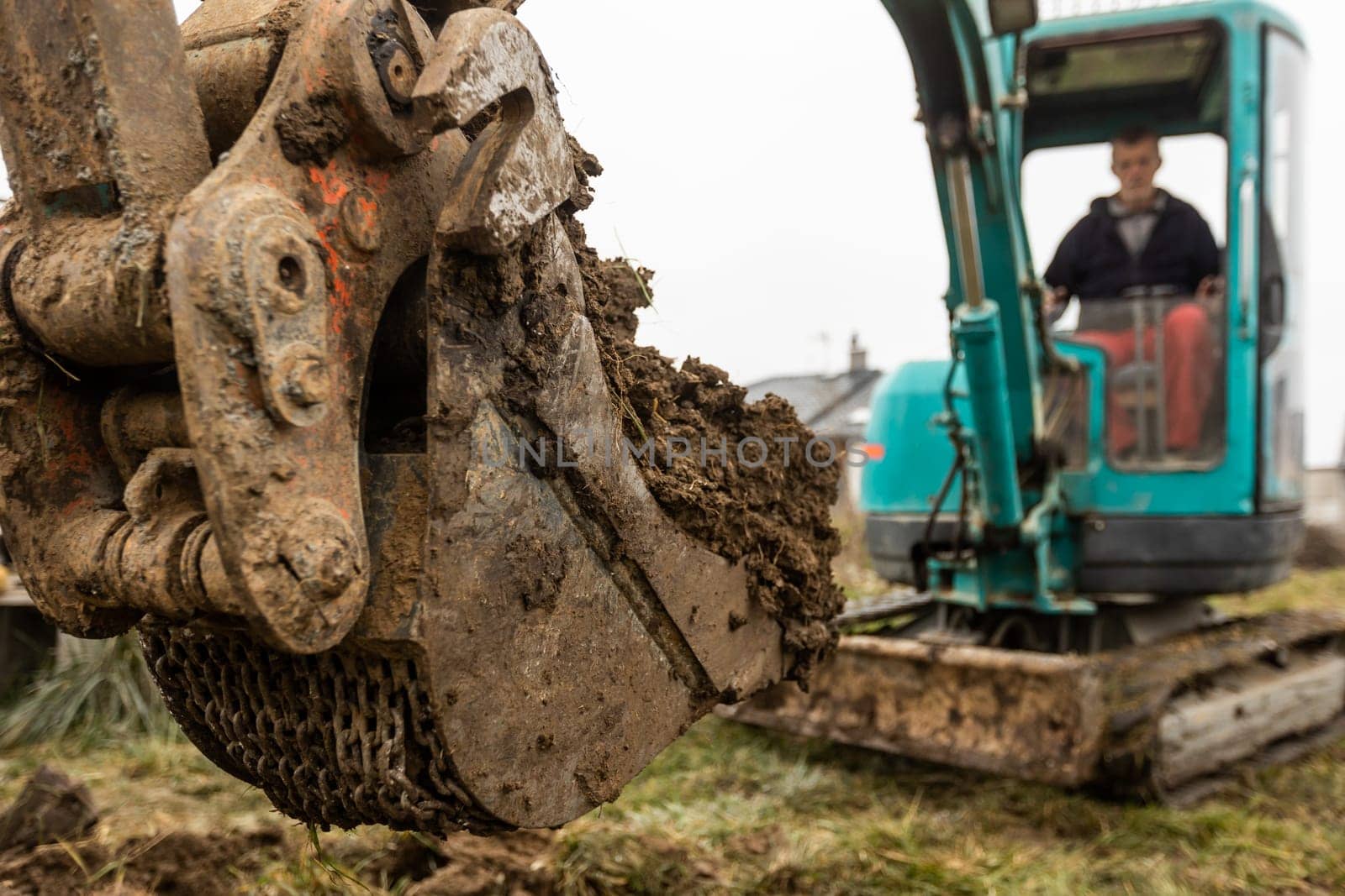 Close up of excavator or digger digging some soil or clay, industrial concept by Kadula