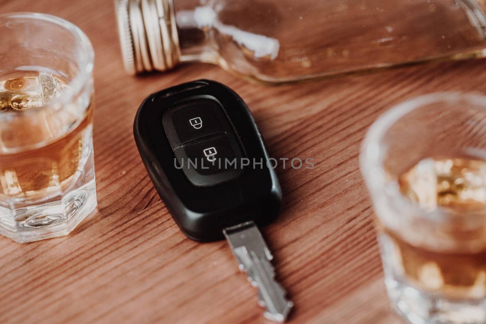 Close up of a car keys and very strong alcohol rum on a table, do not drink and drive concept, driving a car, transportation concept