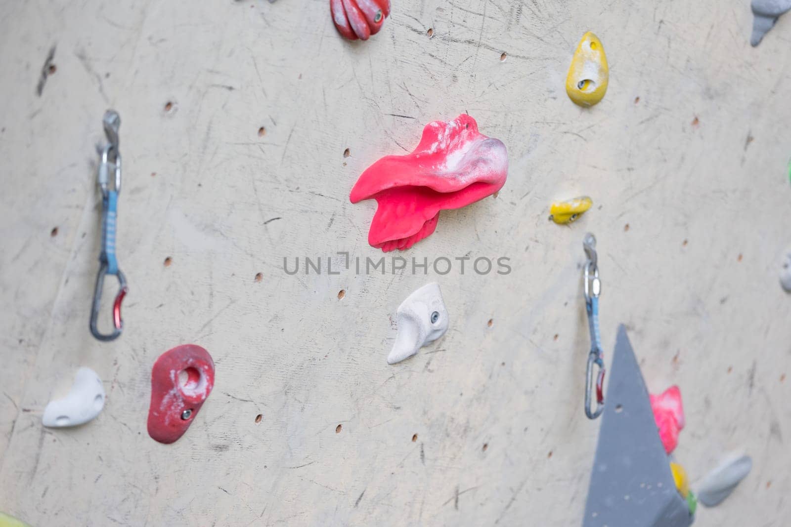 Close up of colorful hooks or grips with carbines for climbing wall