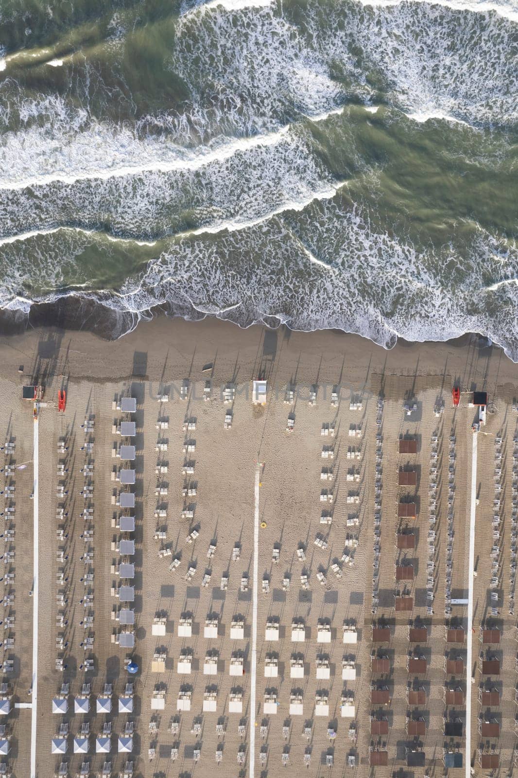 Aerial view of Versilia beach with rough sea photographed from above 