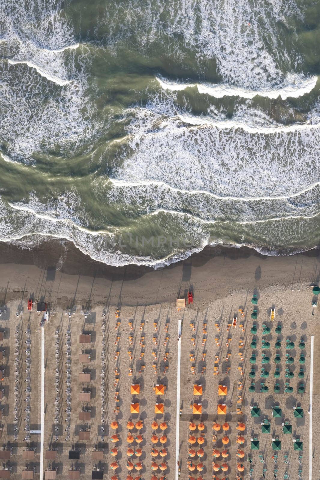 Aerial view of Versilia beach with rough sea photographed from above 