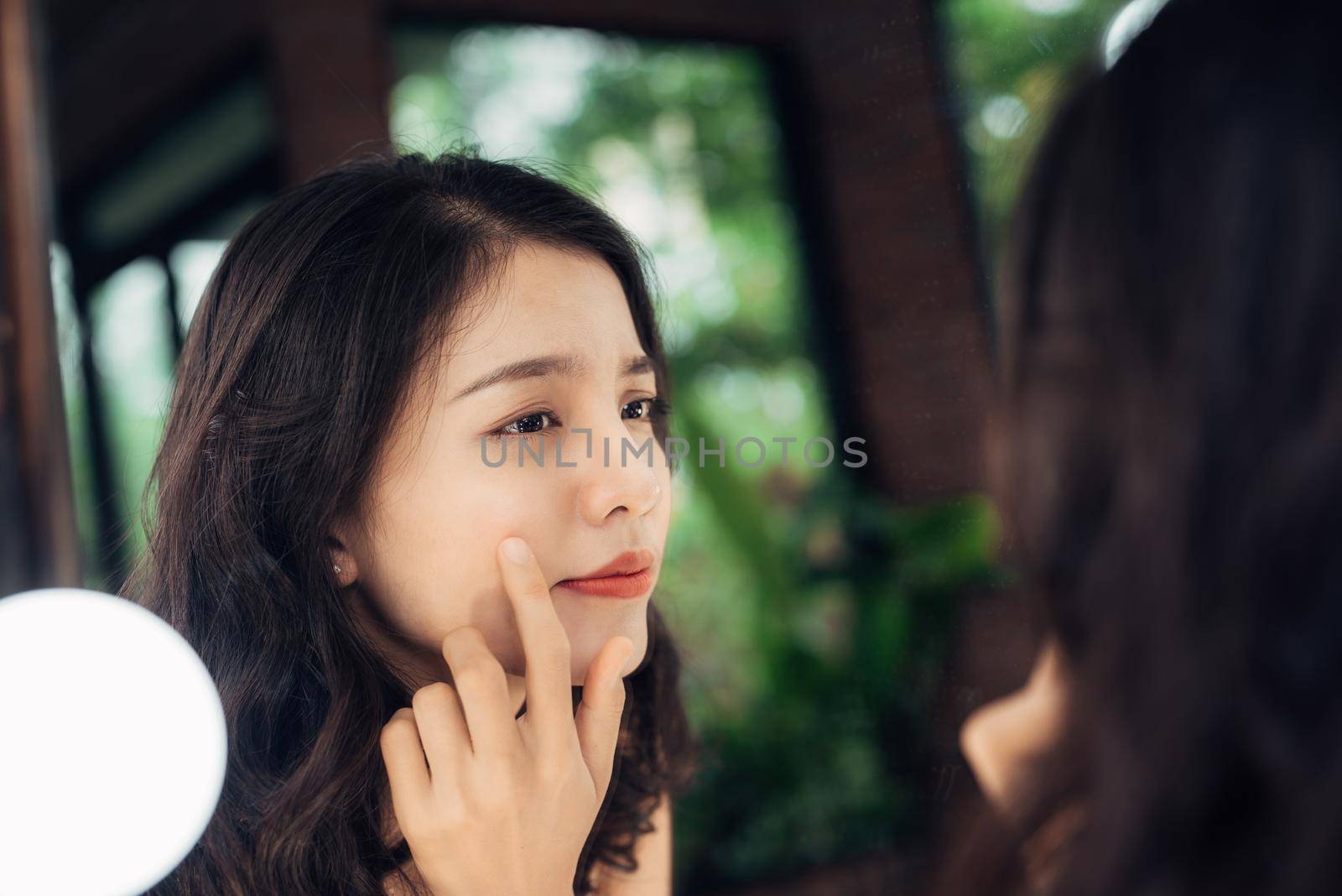 Beauty, skin care lifestyle concept. Young asian woman with acne looking at the mirror.