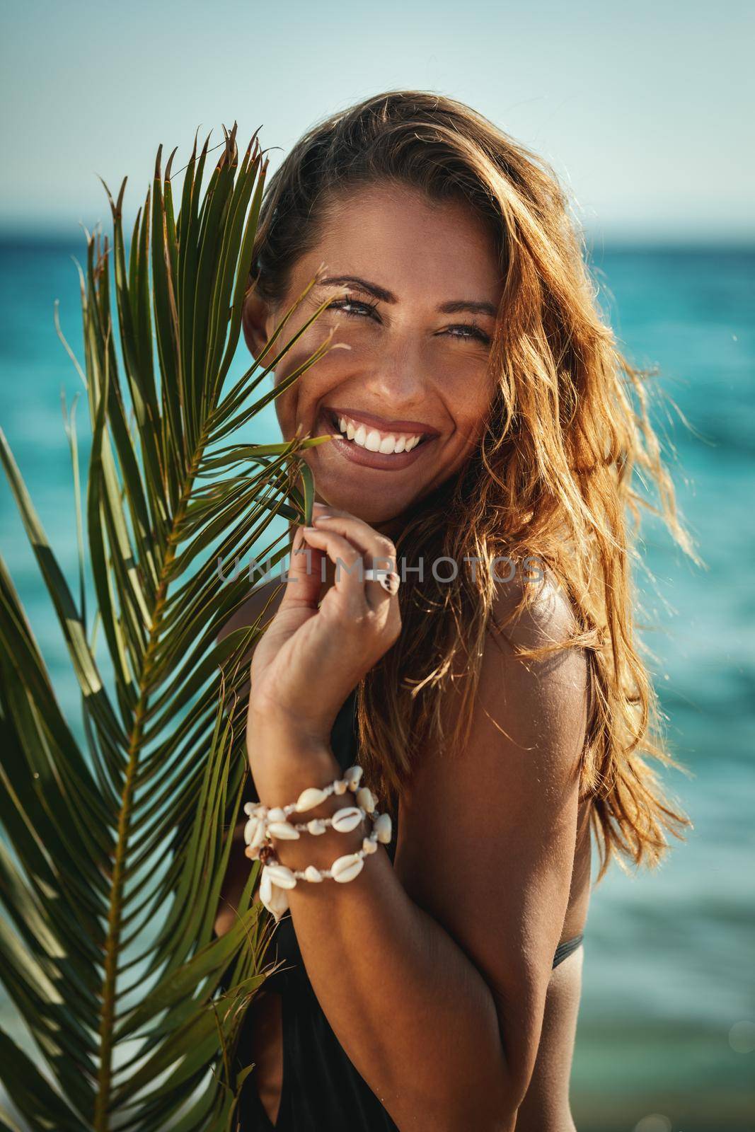 Portrait of an attractive young woman is posing and enjoying at the tropical beach.