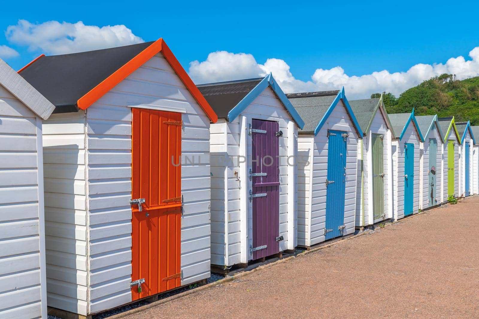 Colorful small beach houses. Multicolored beach sheds. Variety of painted beach shacks. Beach huts. Torbay, South Devon. UK. by Qba