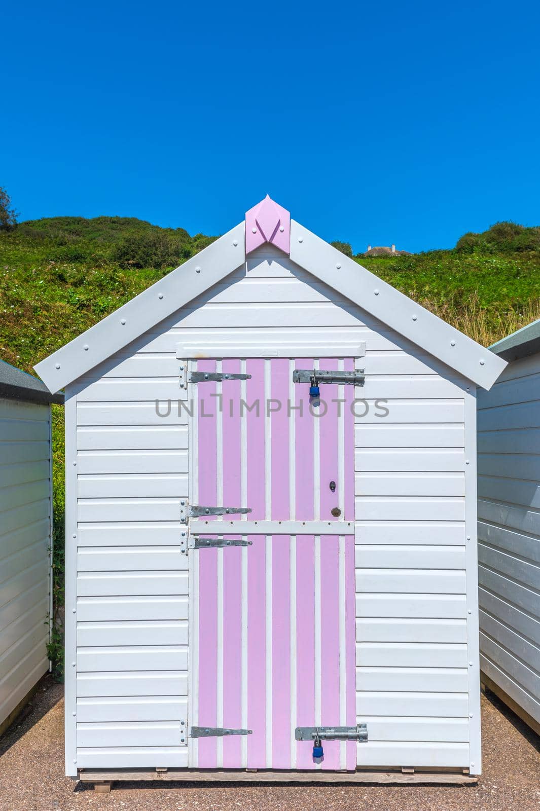 Colourful beach houses. Row of multicolored beach huts against blue sky.