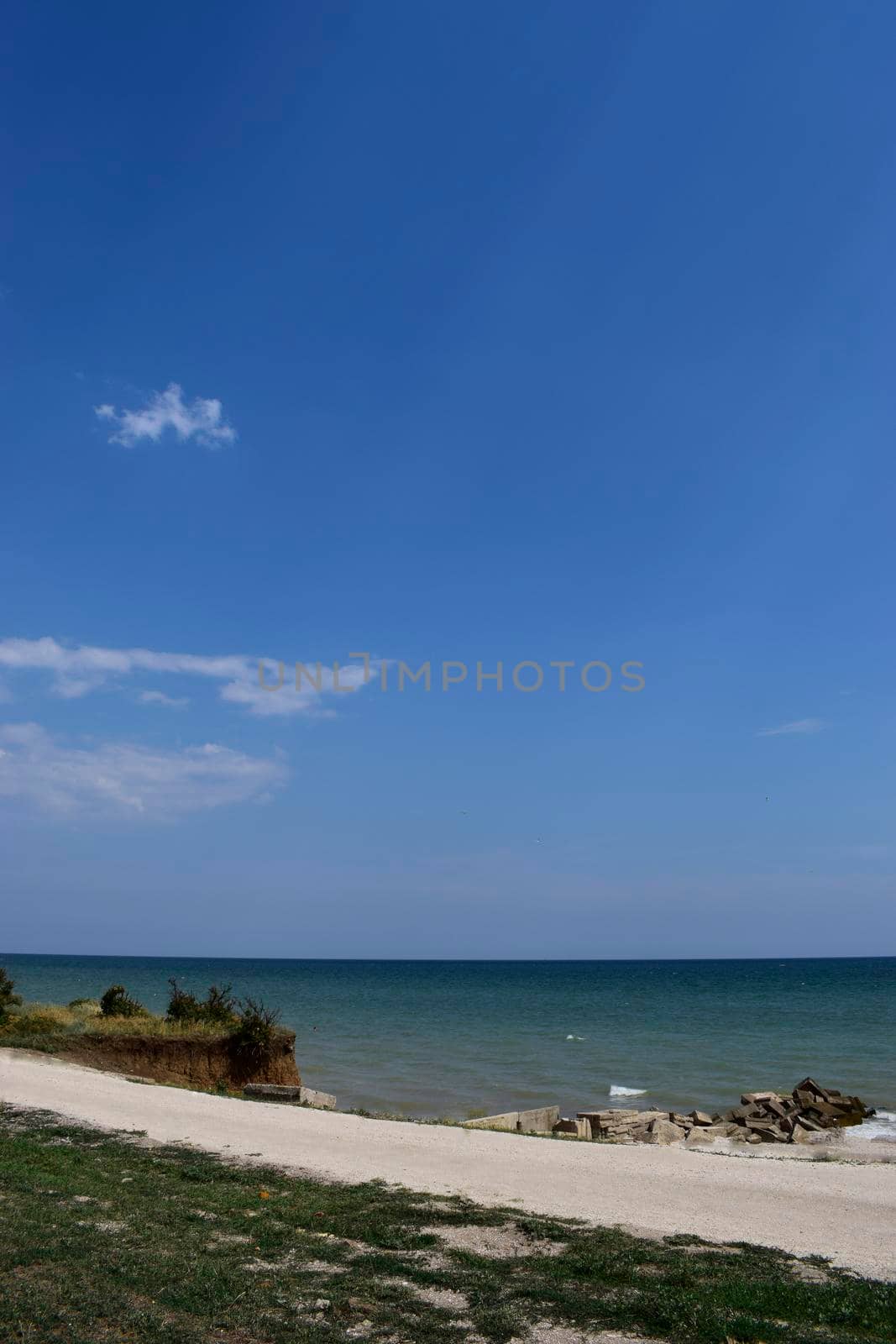 Steep cliff, seashore landscape. Cliff of clay and sea beach. Beautiful summer landscapes with clay cliffs near blue sea.
