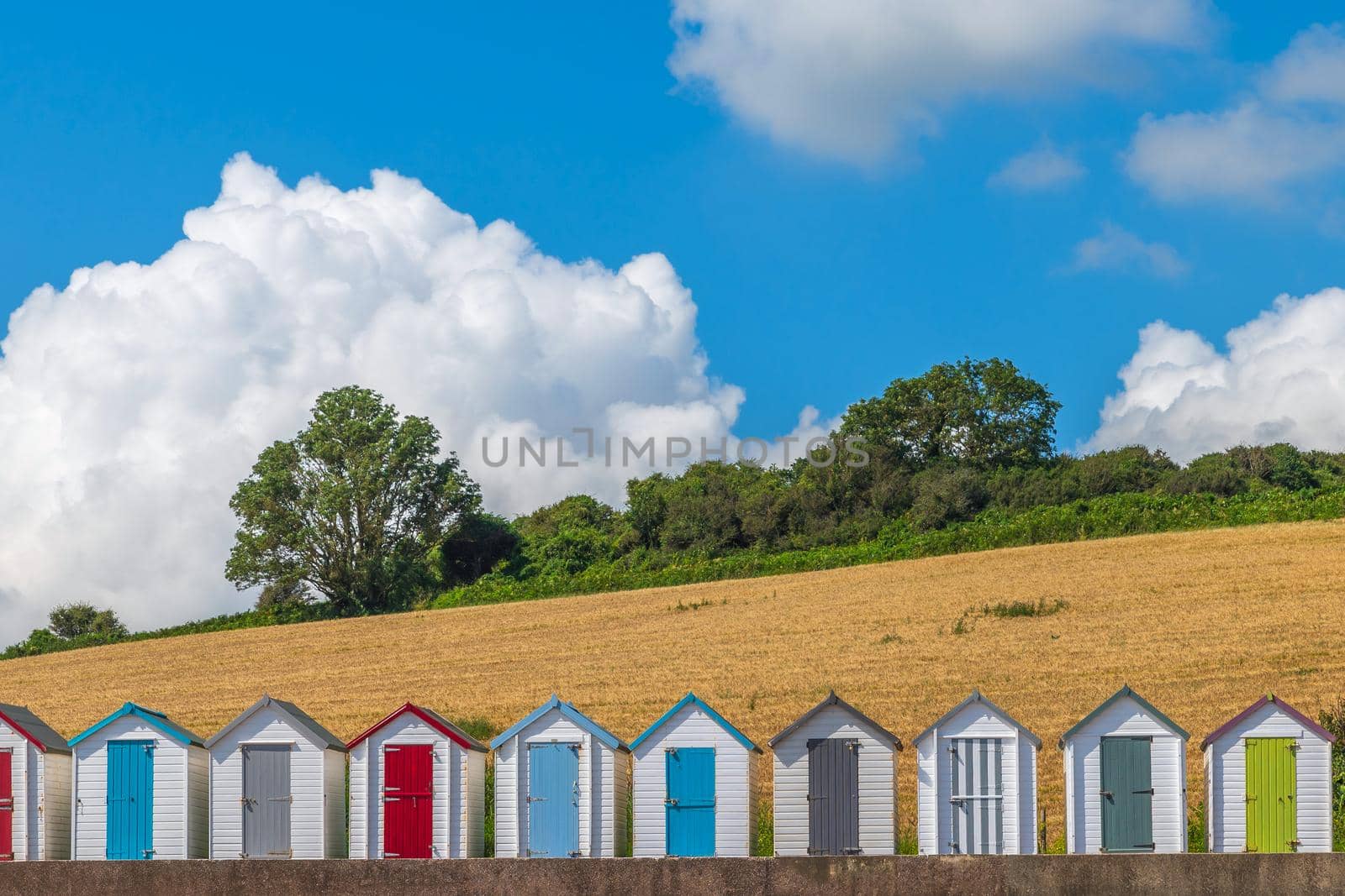 Colourful beach houses. Row of multicolored beach huts against blue sky.