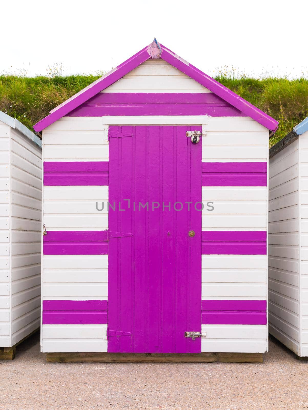 Colourful beach houses. Row of multicolored beach huts against blue sky.