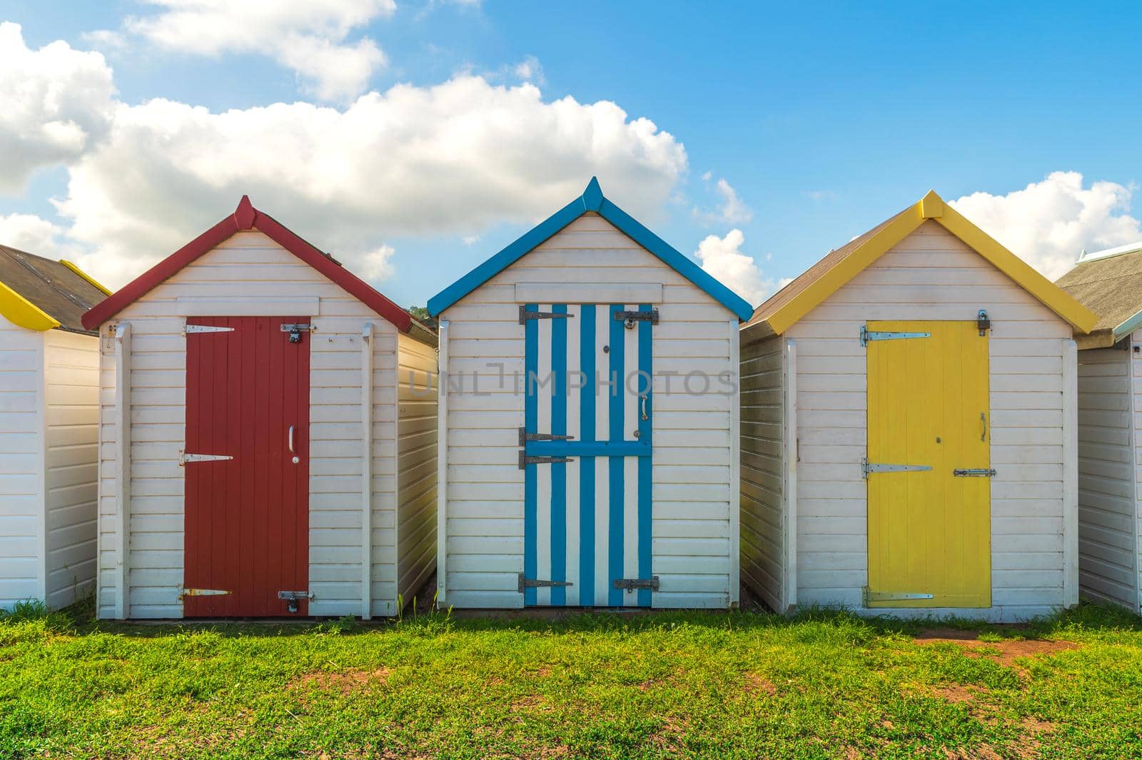 Colorful small beach houses. Multicolored beach sheds. Variety of painted beach shacks. Beach huts. Torbay, South Devon. UK. by Qba
