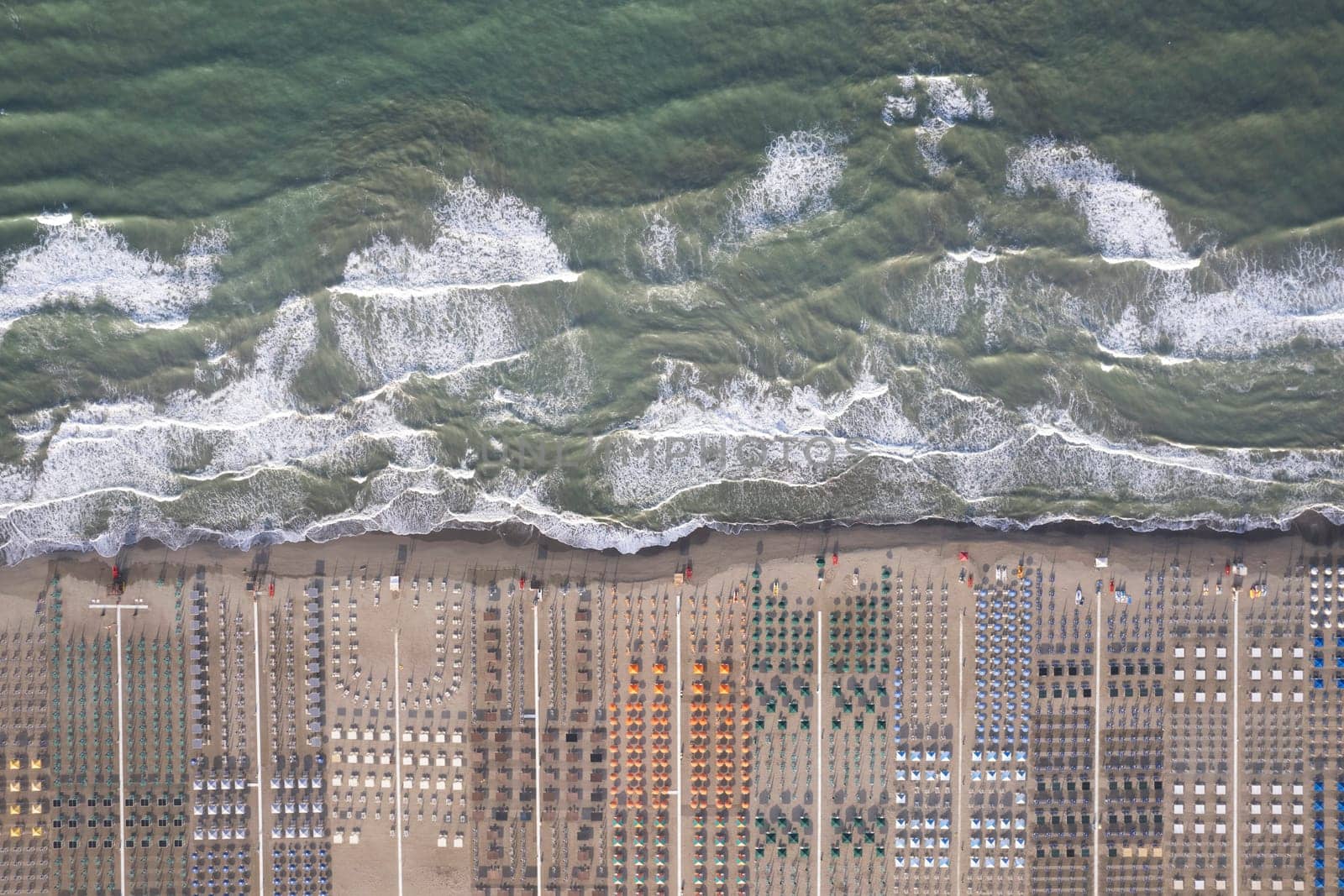 Aerial view of Versilia beach with rough sea photographed from above 