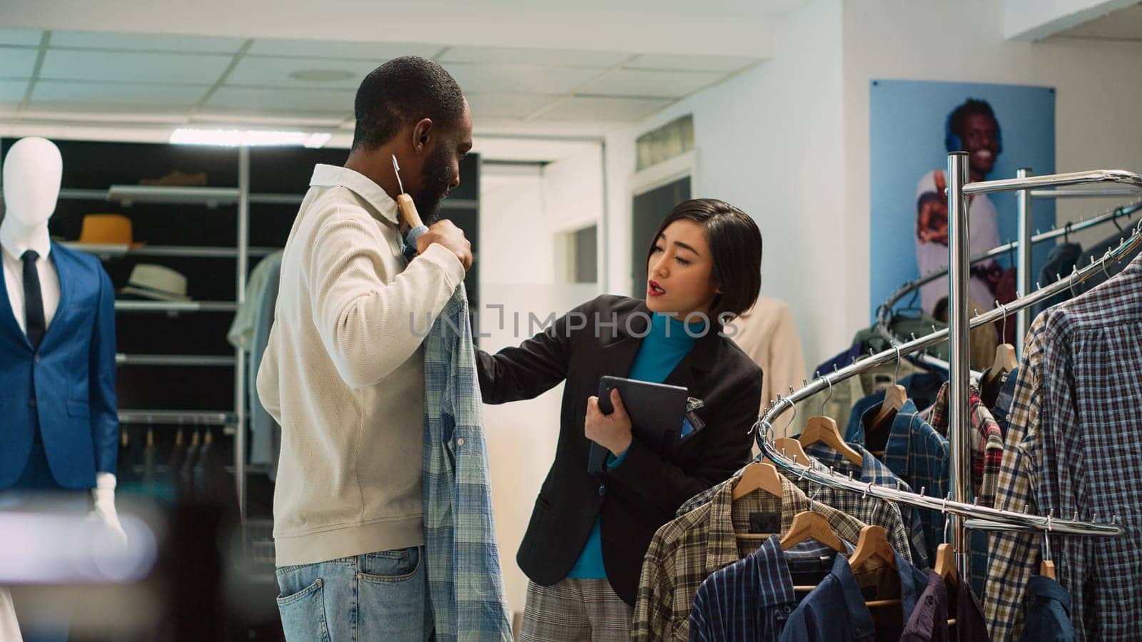 Diverse people examining clothes on racks by DCStudio