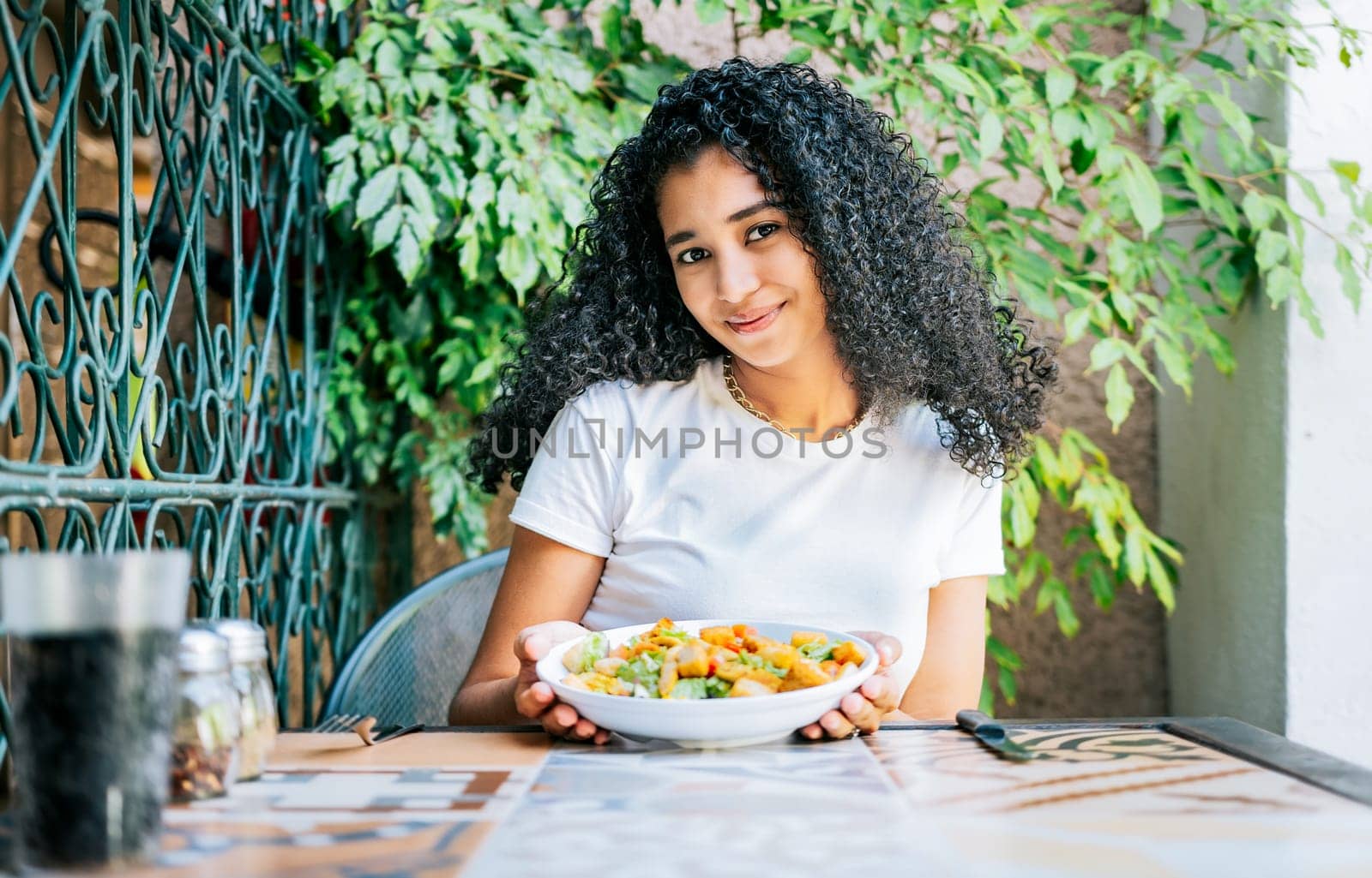 Portrait of smiling girl eating caesar salad. Concept of healthy food and healthy life, Beautiful girl sitting holding a caesar salad