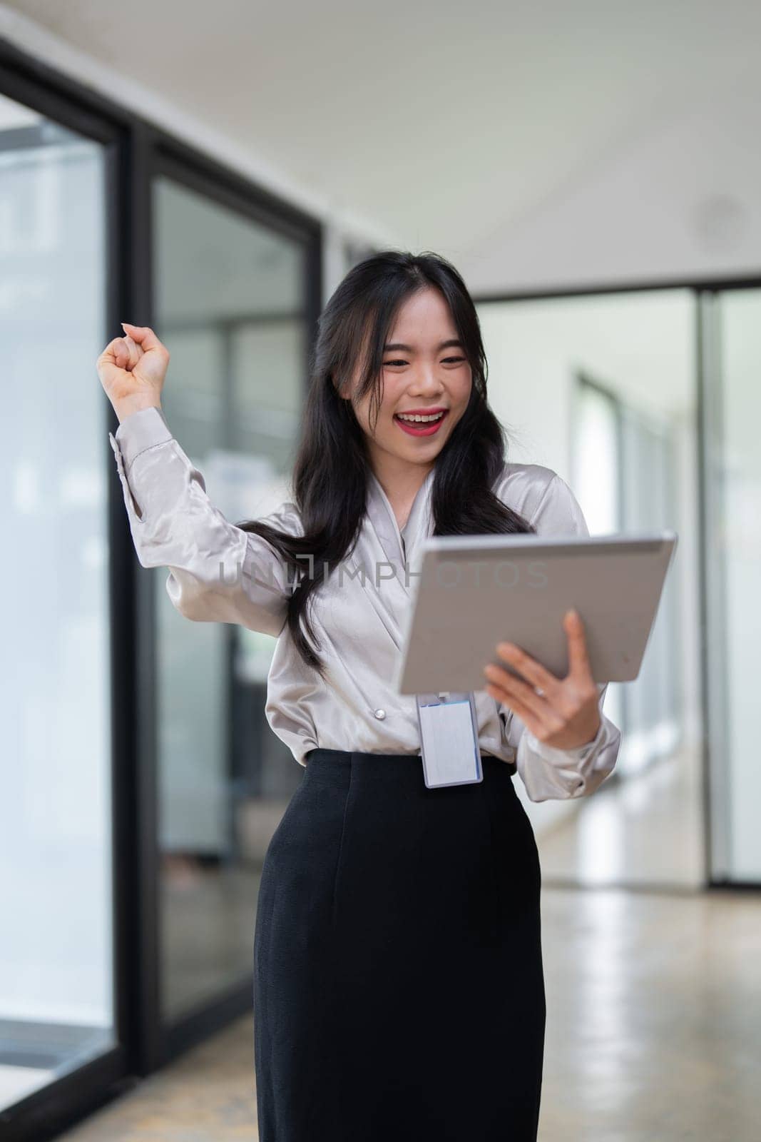 Young businesswoman working successfully in office while standing near window.