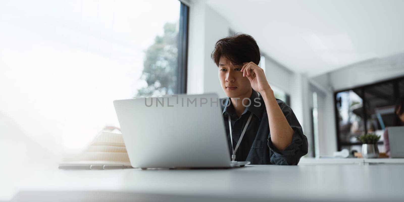 Businessman stressed with work and deadlines Stressed businessman with laptop sitting at desk in office.